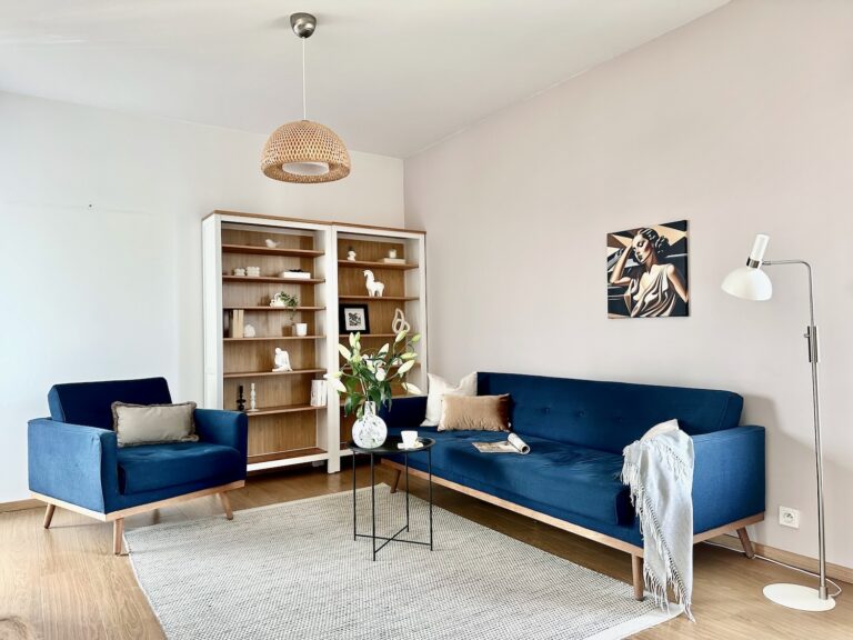 Zaaranżowany do sesji zdjęciowej salon z granatową kanapą po home stagingu. dodatkami
