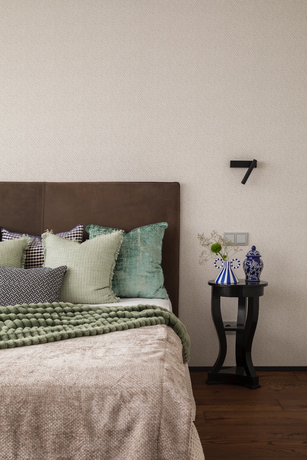 Sypialnia z miękkimi poduszkami i narzutą w odcieniach zieleni i beżu