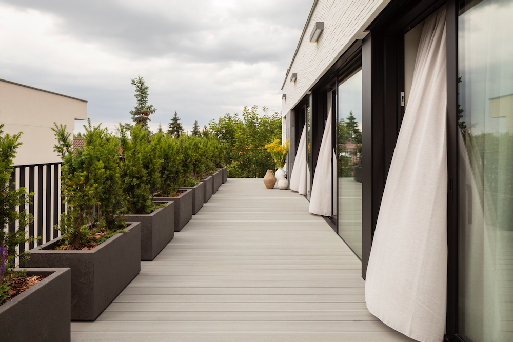 Taras z donicami i zielonymi roślinami przy nowoczesnym apartamencie w Warszawie