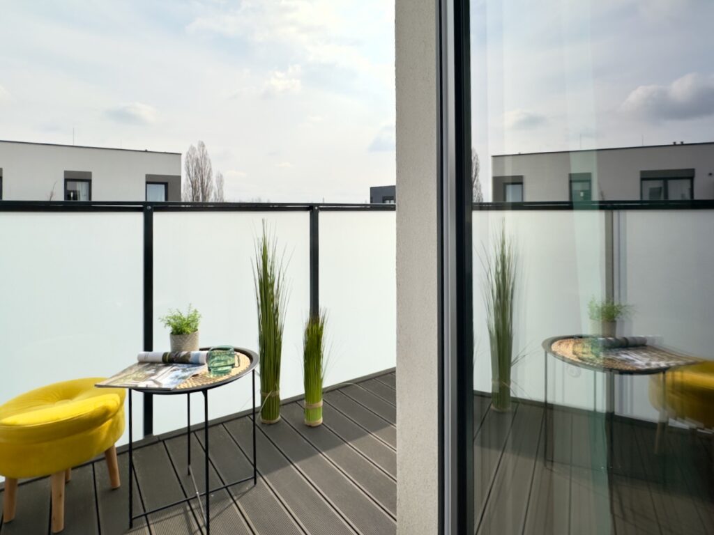 Mały balkon z żółtym fotelem i stolikiem