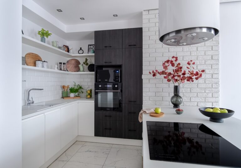 Biała kuchnia z wyspą i czarnymi akcentami