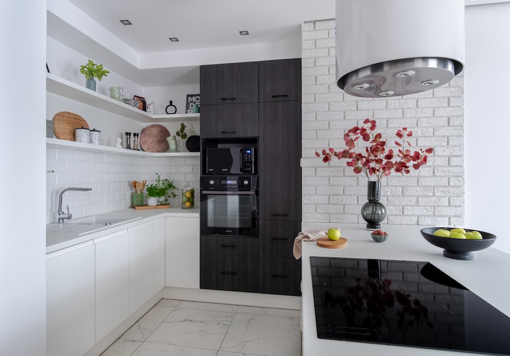 Biała kuchnia z wyspą i czarnymi akcentami