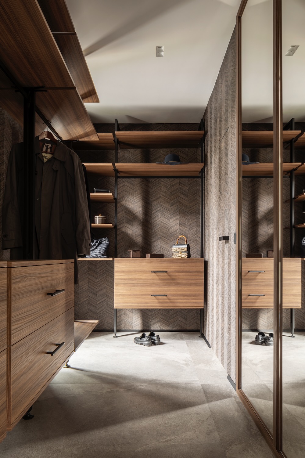 Garderoba z drewnianymi półkami, szufladami i lustrem w eleganckim wnętrzu