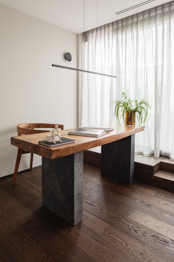 Domowe biuro z masywnym biurkiem z litego drewna i rośliną w wazonie