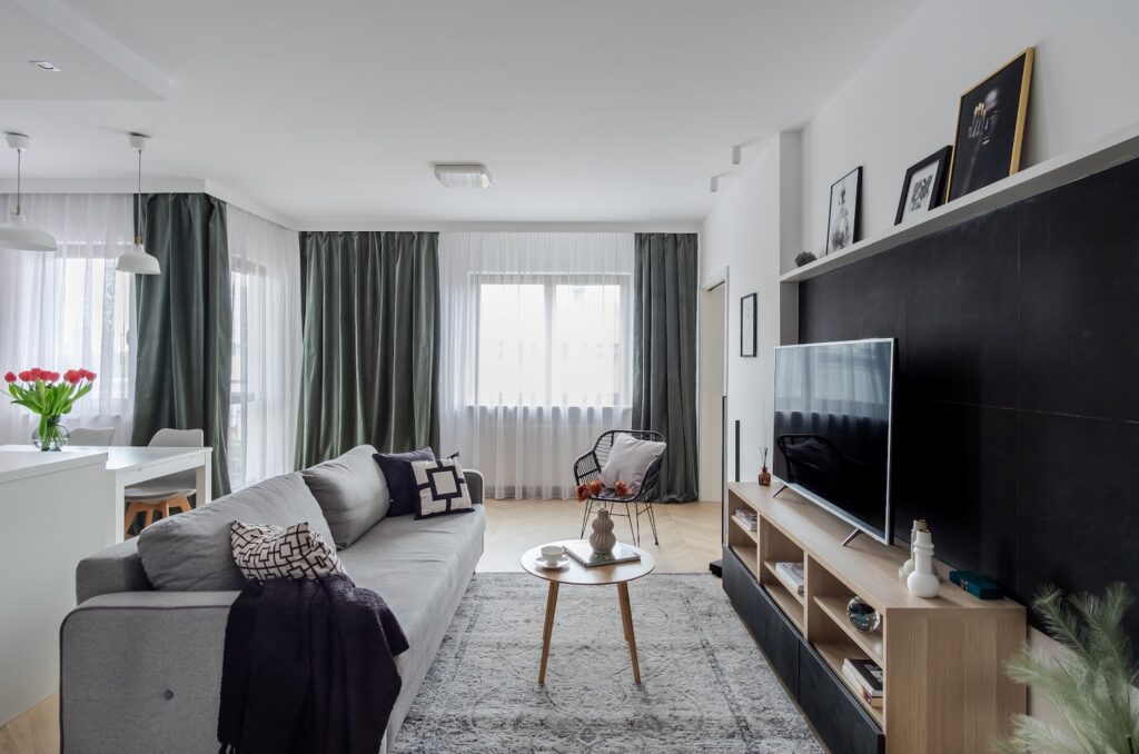 Nowoczesny salon z szarą sofą i telewizorem