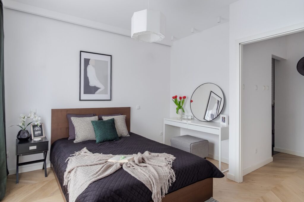 Nowoczesna sypialnia z łóżkiem i toaletką po home staging.