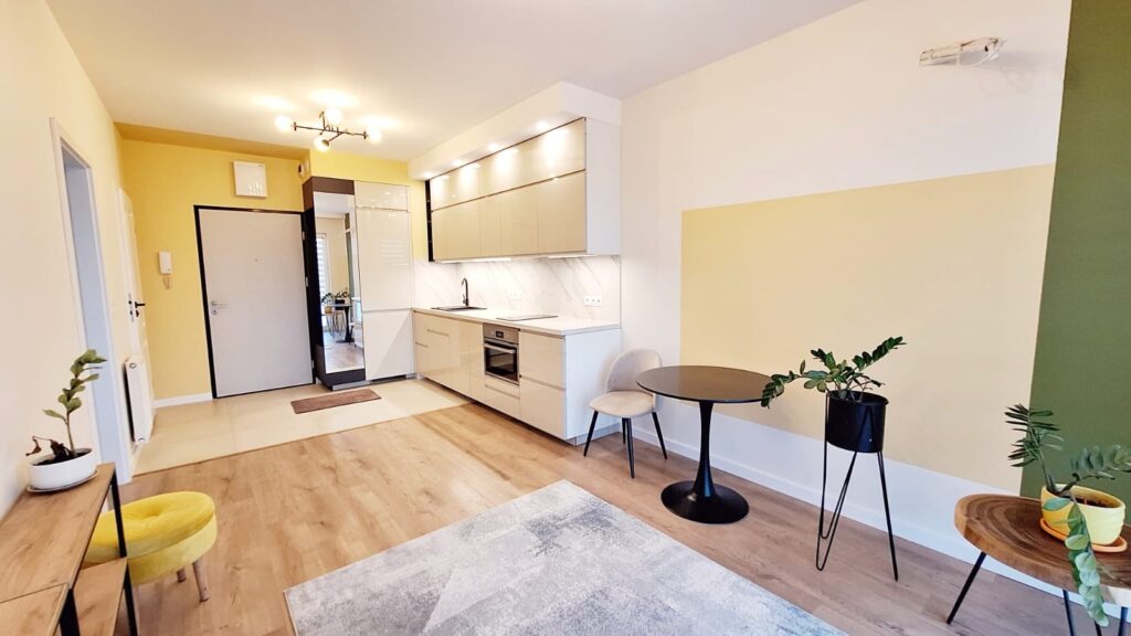 Aranżacja salonu z aneksem kuchennym w jasnych kolorach – home staging Piaseczno