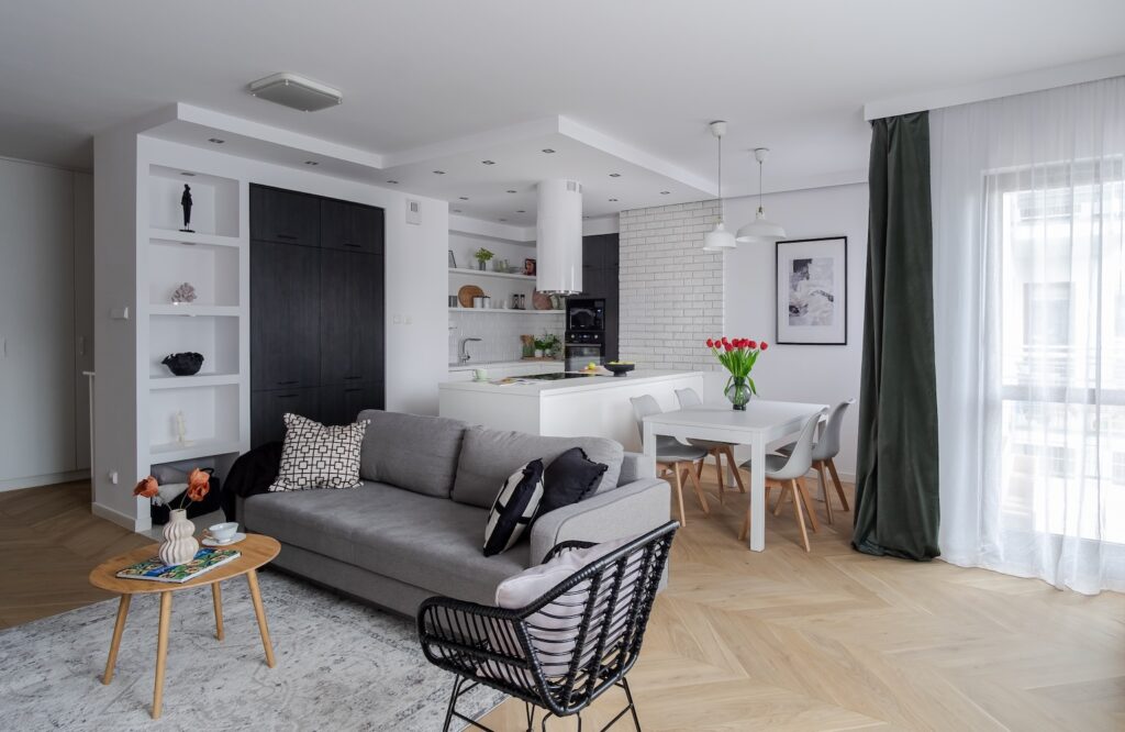 Nowoczesny salon z kuchnią w jasnych kolorach po home stagingu.