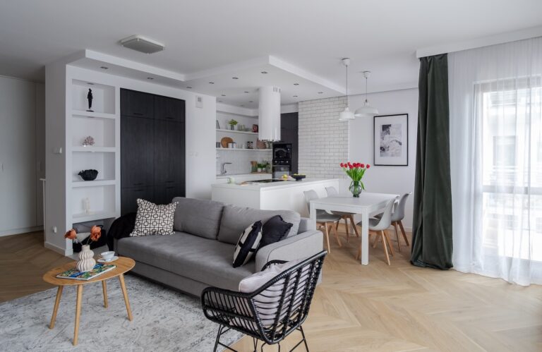 Nowoczesny salon z kuchnią w jasnych kolorach po home stagingu.