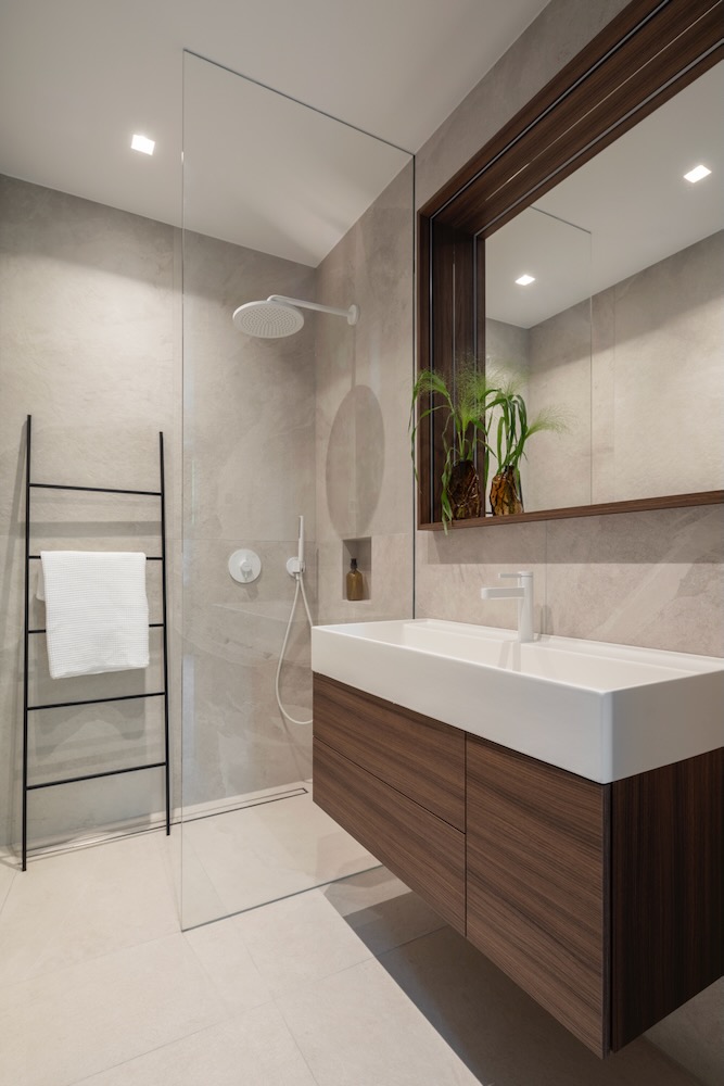 Nowoczesna łazienka z prysznicem typu walk-in, drewnianą szafką i dużym lustrem