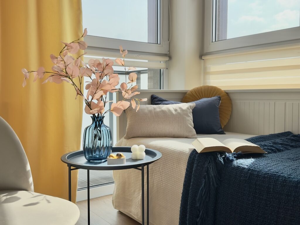 Sypialnia z pastelowymi dodatkami i wazonem w aranżacji home staging Warszawa