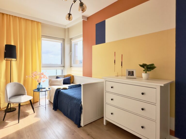 Sypialnia z kolorową ścianą i żółtymi zasłonami w aranżacji home staging Warszawa