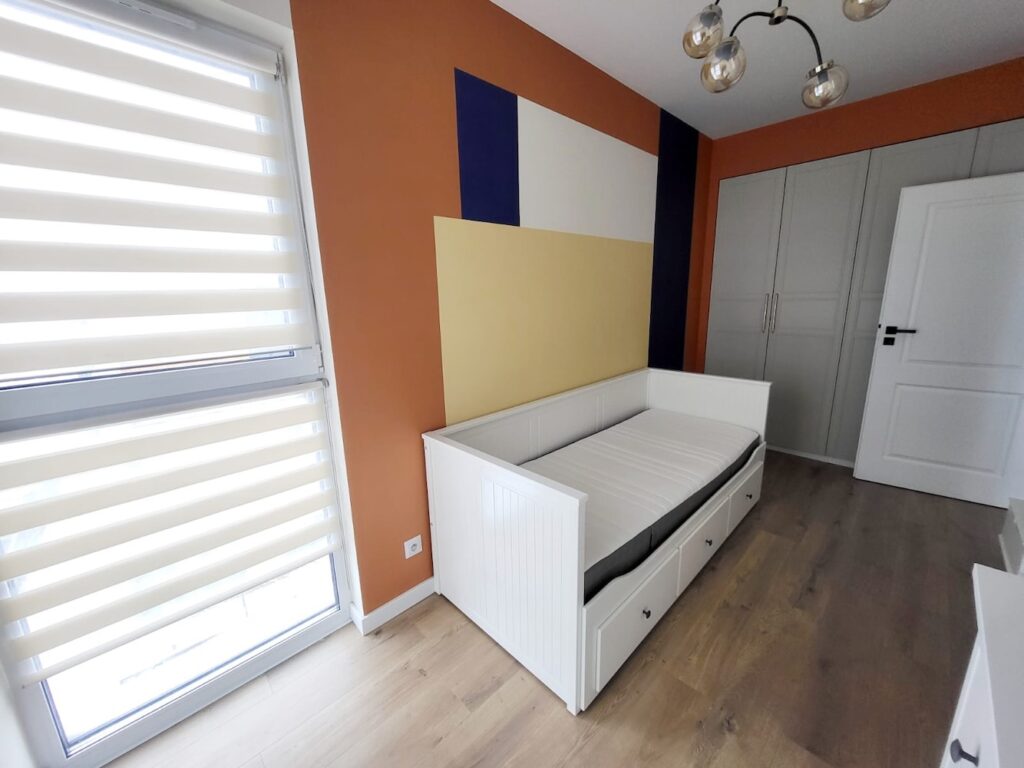 Kolorowa sypialnia z geometrycznym wzorem i łóżkiem w zabudowie – home staging Warszawa