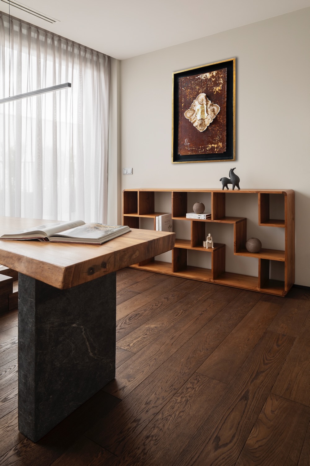 Jasne wnętrze z drewnianym stołem i regałem, obrazem i delikatnymi zasłonami